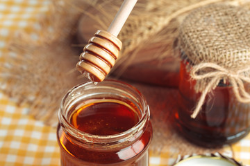 Honey background. Sweet honey in glass jar on wooden background.