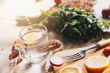 Healthy vegan food background with cutting board and lemon slices. Top view to organic food background with cutting board and lemon slices