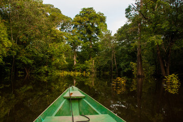 Amazon river, Manaus, Amazonas, Brazil: Wooden boat floating on the Amazon river in the backwaters...