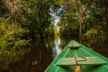 Amazon river, Manaus, Amazonas, Brazil: Wooden boat floating on the Amazon river in the backwaters...