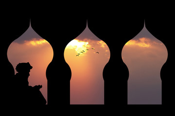 Islamic man reads the Koran at sunset