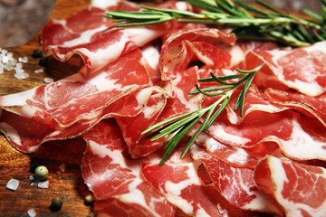 Italian sliced cured coppa with spices. Raw ham. Crudo or jamon with rosemary