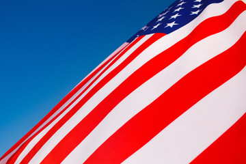 Fototapeta na wymiar American flag flying in the wind against a blue sky