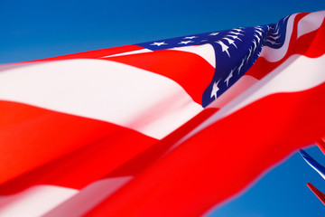 American flag flying in the wind against a blue sky