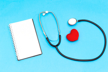Stethoscope and notebook and red heart ,cardiogram on blue background. Cardiology concept