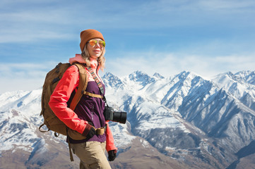 Portrait of photographer hipster tourist girl with a camera in sunglasses and a hat against the...