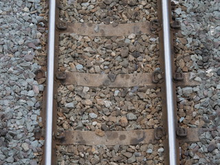 Top view of the train tracks with train and rock restraints in construction.