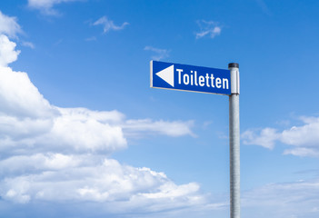Information sign with the german word for toilets,, blue sky and cloudy background
