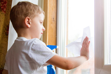 the boy in the yellow gloves washes a window