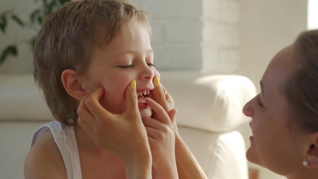 6 year old boy eating green apple and try pull out baby teeth