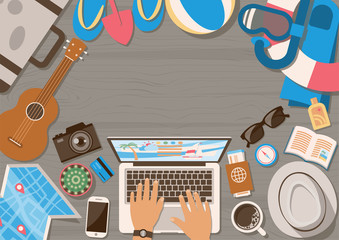 Hands of man planning trip on laptop with summer vacation elements on wooden table from top view in flat style