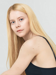 Pure skin Close-up photo Fashion portrait of a young blonde woman with clean skin and moles in her arms