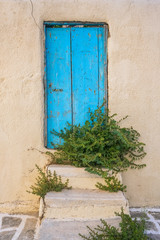 White house facade with traditional blue door on Paros island, Cyclades