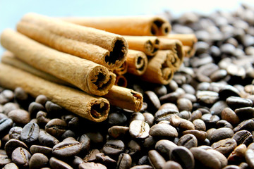 Cinnamon sticks and coffee beans closeup. Aromatic coffee - coffee beans and cinnamon sticks. Background. Copy space.