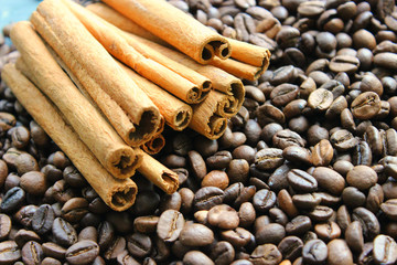 Cinnamon sticks and coffee beans closeup. Aromatic coffee - coffee beans and cinnamon sticks. Background. Copy space.