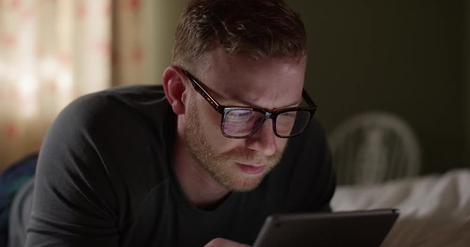 4K Closeup worried man staring at computer screen with serious expression. Slow motion.