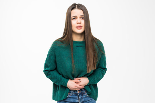 Young pretty woman with stomack pain wearing in green sweater isolated on white background
