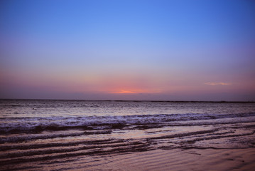 Obraz premium waves in the sea and orange and blue sky after the sunset.