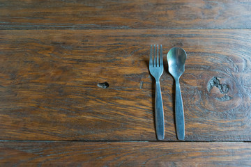 Spoon and fork on the wood background