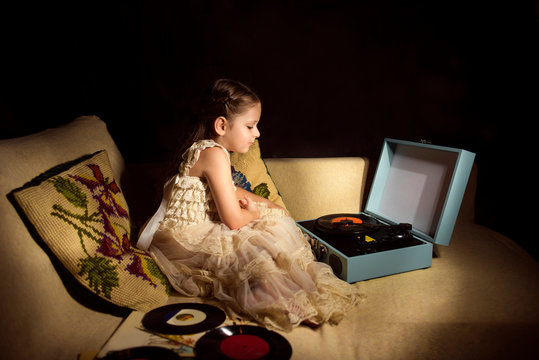 Little caucasian girl listening a phonograph record
