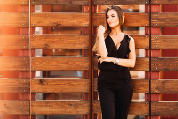girl on the background of a wooden fence. stylish clothes