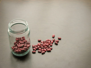 Red bean seeds in a glass jar on the wooden table