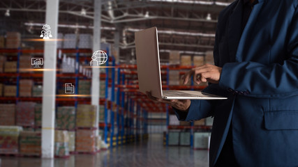 Businessman manager using laptop check orders online goods worldwide for network with Modern Trade warehouse logistics.