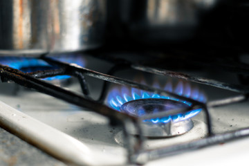 Burning gas burner on stove. Blue flame from burning gas