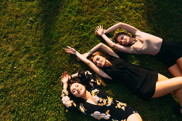 the girls closed their eyes and lay on the grass and raised thei