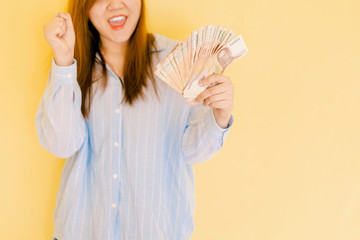 web banner design home business and job success concept from soft focus beauty woman in happiness feeling show lot of banknote with yellow pastel background