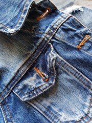 Fragment of a denim jacket with a pocket and collar