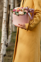 Beautiful woman holding pink box with flowers. Gift to Women's Day. Agency floral design, place text