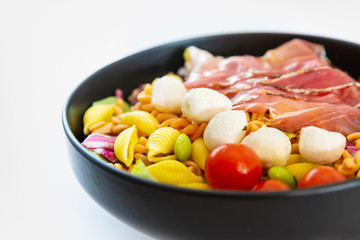 Salad made with cooked pasta, mixed green salads, cherry tomatoes, Mozzarella cheese and smoked ham served with accompaniment