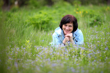 Beautiful mature woman posing for the camera in the spring garden. The girl enjoys the flowering .