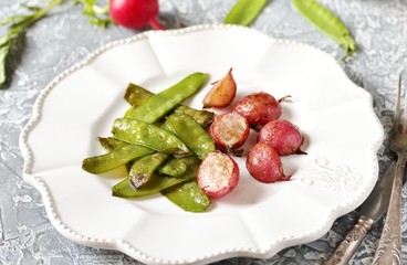 Fried young peas and radish pods. In the style of Provence. light background. Soft focus