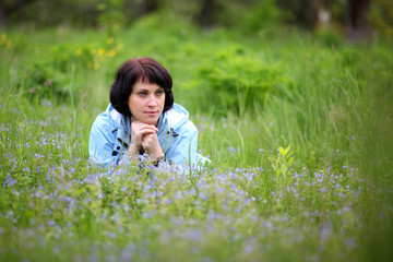 Beautiful mature woman posing for the camera in the spring garden. The girl enjoys the flowering .