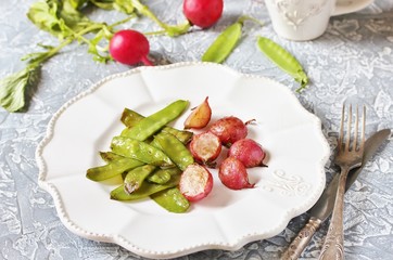 Fried young peas and radish pods. In the style of Provence. light background. Soft focus