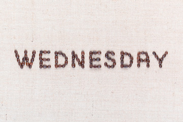 The word Wednesday written with coffee beans , aligned in the center, closeup.