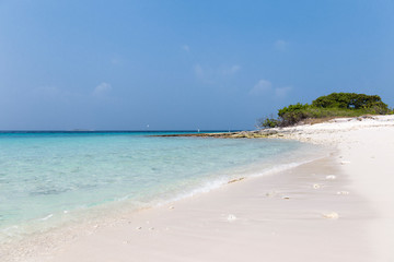 Small island in the Maldives surrounded by perfect crystal clear turquoise water
