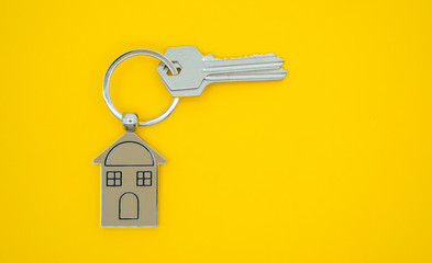 key chain with house symbol and keys on yellow