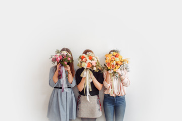 Three young girls florists made beautiful bouquets