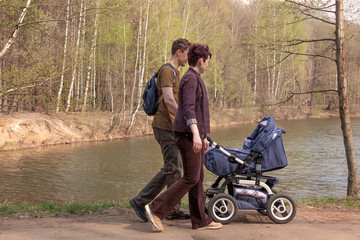 young parents with a baby stroller for a walk