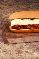 closeup meatball sub sandwich on wood cutting board