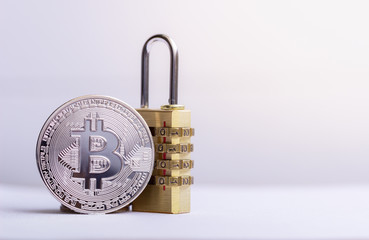 Bitcoin(BTC) coin with padlock lying on white background..Bitcoin security. digital cyber safety or security encryption, Blockchain technology to encode online information or data protection.