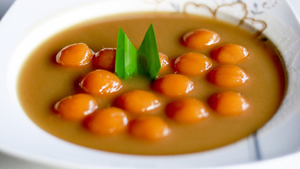 Biji salak on white background. Biji salak is sweet potato dumplings with coconut sauce. Popular dessert in Indonesia or to break the fast.