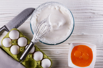 young woman in a gray aprons breaks the eggs