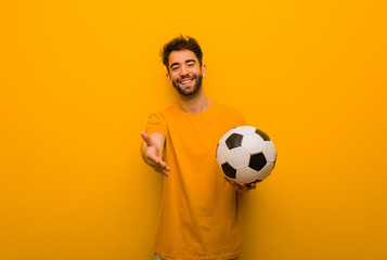 Young soccer player man reaching out to greet someone