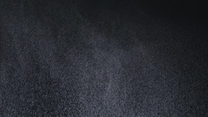 White exploding powder over black background