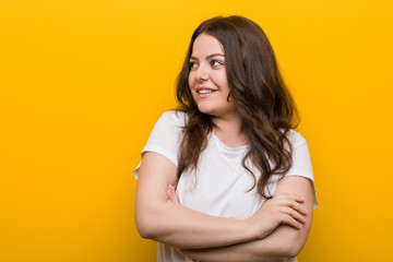Fototapeta premium Young curvy plus size woman smiling confident with crossed arms.