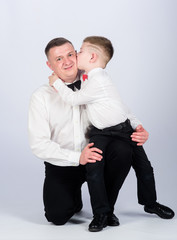 kid kiss his father. tuxedo style. little boy with dad businessman. family day. esthete. male fashion. happy child with father. business meeting party. father and son in formal suit. love kiss